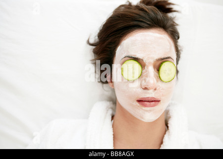 Portrait of young woman's face relaxant à visage pack et fermer les yeux Banque D'Images