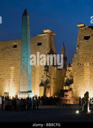 Pylône avec chiffres et obélisque de Ramsès II de lumière le soir, en face d'un minaret, le temple de Louxor, Louxor, Egypte, Af Banque D'Images