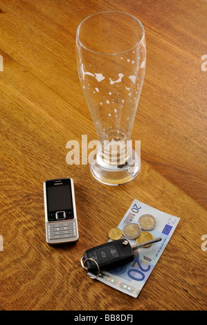 Verre vide de bière de froment, clés de voiture, symbolique de l'alcool au volant Banque D'Images