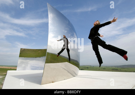 Guide Festival Helen Goodwin bondit en face de Courbe C le contre-batteur énorme miroir en acier inoxydable installation par Anish Kapoor Banque D'Images