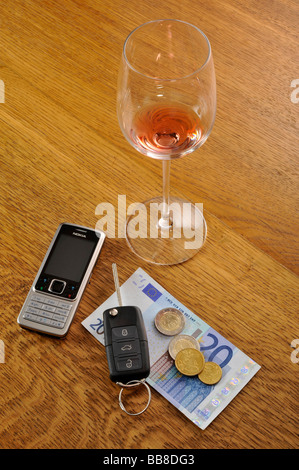 Verre vide de vin rouge, clés de voiture, symbolique de l'alcool au volant Banque D'Images