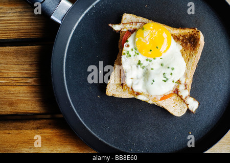 Œuf frit sur toast avec la ciboulette dans une poêle Banque D'Images