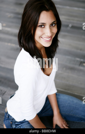 Portrait of young smiling belle femme agenouillée Banque D'Images