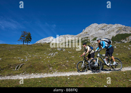 Riders vtt, hommes et femmes entre Karwendelhaus, alpine club house, et Kleiner Ahornboden Forest District, Hinterri Banque D'Images