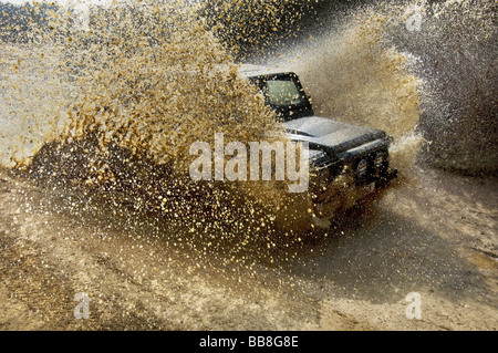 Une Landrover Defender conduisant par une inondation sur un exercice hors route Banque D'Images