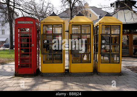 Anglais 1 rouge et 3 Jaune allemand des cabines téléphoniques dans une rangée Traunstein Bavaria Allemagne Banque D'Images