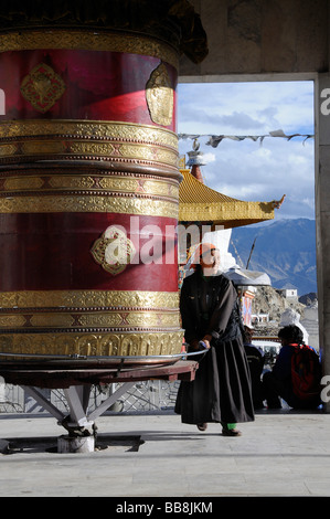 Moulin à prières géant avec une femme ladakhis portant un costume traditionnel à Leh, Ladakh, Inde du Nord, Himalaya, Asie Banque D'Images