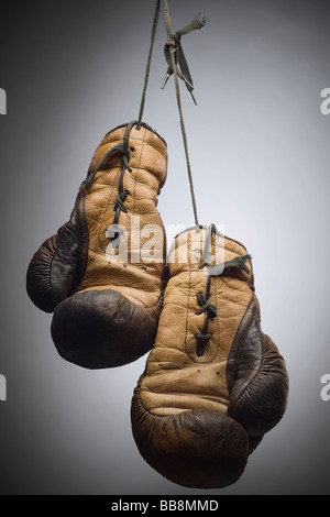 Une paire de gants de boxe usé suspendu à la chaîne Banque D'Images