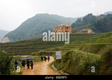 Filles Hmong noir marche à travers le village lao Chai à Sapa, Vietnam du Nord Ouest Banque D'Images
