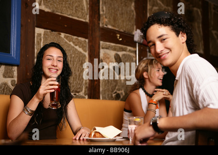 Trois adolescent smiling in restaurant Banque D'Images