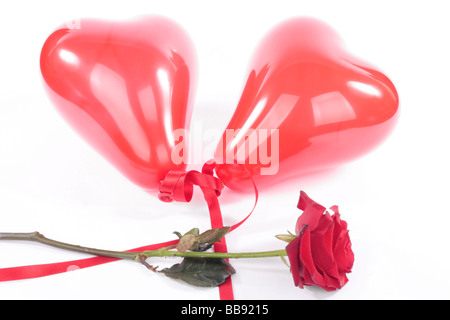 Rose rouge en forme de cœur et plus de ballons fond blanc Banque D'Images