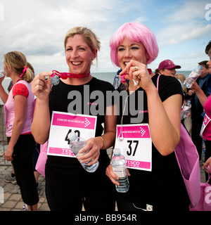 Deux femmes en compétition dans la course pour la Vie parrainé exécuter pour lever des fonds pour la recherche sur le cancer au pays de Galles Aberystwyth UK Mai 2009 Banque D'Images