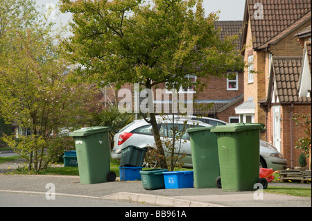 Rangée de bacs verts wheelie contenant les ordures et les bacs de recyclage en plastique dans une rue en attente de collection Banque D'Images