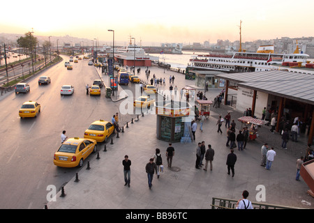 Istanbul Turquie soir scène au bord de l'embarcadère des ferries d''Eminönü avec les piétons et les taxis Banque D'Images