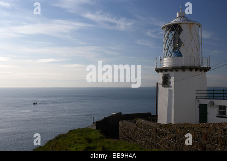 Le point noir whitehead phare sur falaise donnant sur la mer avec petit bateau de pêche bien en dessous le comté d'Antrim Banque D'Images