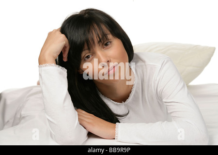Young attractive woman lying on bed Banque D'Images