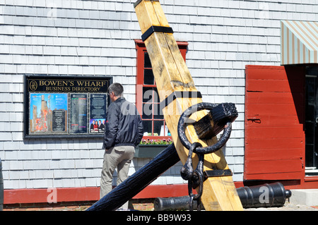 Man annuaire s'abonner à Bowens Wharf centre commercial avec de vieux navires en premier plan d'ancrage dans le port de Newport Rhode Island Banque D'Images