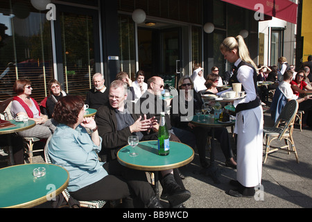 Waiter serving clients assis à l'extérieur d'un café sur le Linden, Berlin, Allemagne Banque D'Images