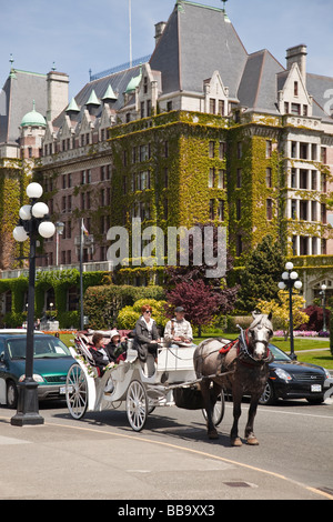 Transport de chevaux avec l'hôtel Empress à l'arrière-plan le jour de Victoria à Victoria (C.-B.), Canada Banque D'Images