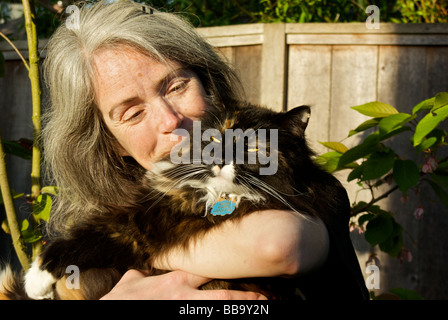 Femme aux cheveux longs câlins chat norvégien Banque D'Images