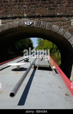 Un bateau étroit passage sous un pont, du canal de Shropshire Union, Angleterre Banque D'Images