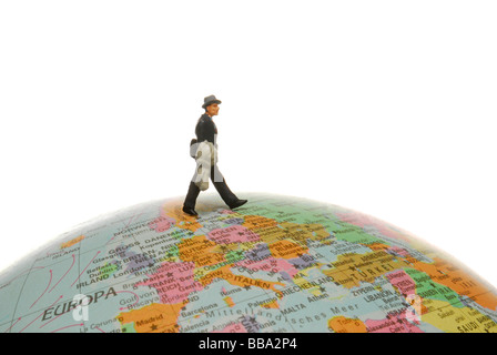 Figure d'une miniature businessman walking sur un globe, image symbolique du commerce international Banque D'Images