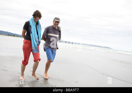 Couple en train de marcher le long de la plage Banque D'Images