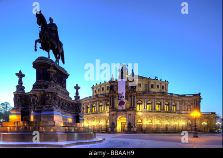 L'opéra Semperoper avec drapeaux et éclairés la nuit et Johann Koenig, mémorial, place Theaterplatz Dresde, Free State Banque D'Images