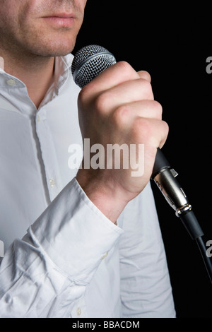 Un homme tenant un microphone Banque D'Images