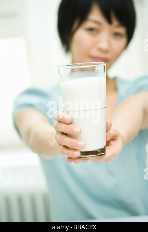 Une femme tenant un verre de lait Banque D'Images