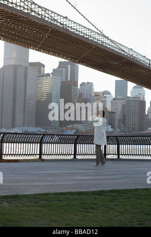 Une femme de prendre une photo près du pont de Brooklyn, New York City Banque D'Images