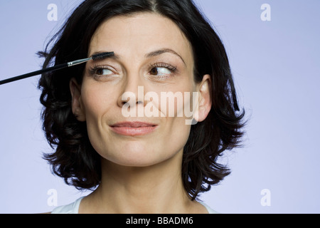 Portrait of a woman applying makeup Banque D'Images