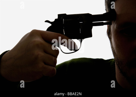 Détail d'un homme tenant un pistolet à sa tête Banque D'Images
