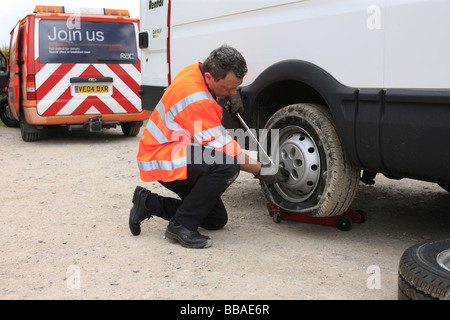 Récupération de l'homme modifie la répartition des pneus sur un panneau blanc van Banque D'Images