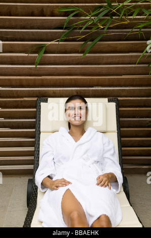 Une femme couchée dans une chaise de salon Banque D'Images