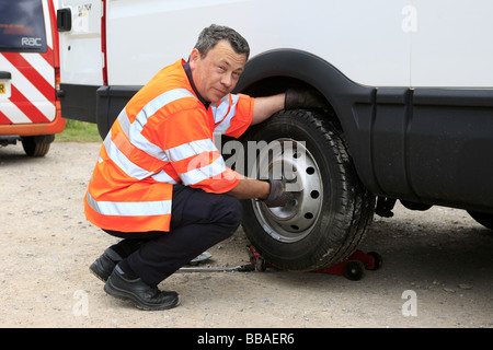 Récupération de l'homme modifie la répartition des pneus sur un panneau blanc van Banque D'Images