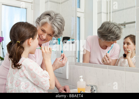 Une grand-mère d'aider sa petite-fille se brosser les dents Banque D'Images