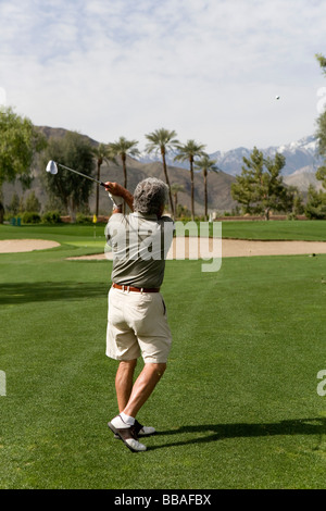 Vue arrière d'un homme en jouant au golf, Palm Springs, California, USA Banque D'Images