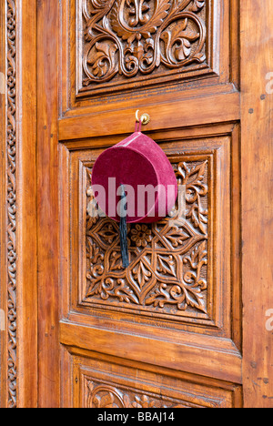 Fex accroché sur une porte richement sculptée, La Villa des Orangers, Marrakech, Maroc Banque D'Images