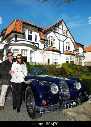 Couple devant leur maison et voiture Banque D'Images