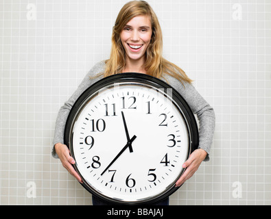 Femme tenant une grosse horloge Banque D'Images
