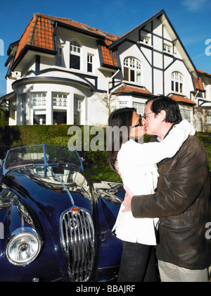 Couple devant leur maison et voiture Banque D'Images