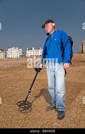 La détection de métal d'un homme sur la plage de Brighton en essayant de trouver de l'argent Banque D'Images