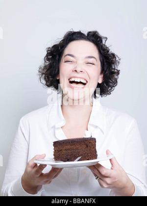 Femme tenant une assiette de gâteau Banque D'Images