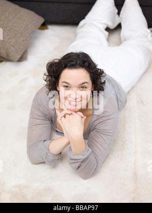 Une femme se détendre sur le plancher. Banque D'Images