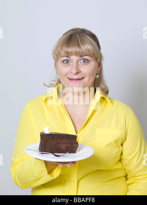 Femme tenant une assiette de gâteau Banque D'Images