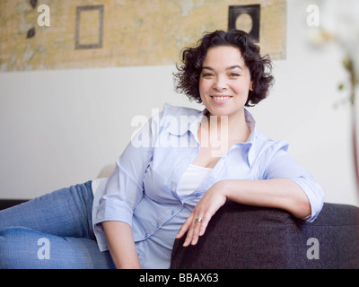 Détente femme sur le canapé. Banque D'Images