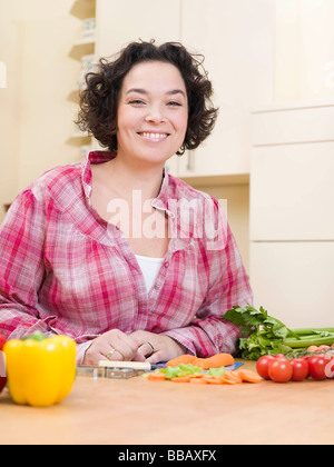 Femme assise en face de légumes Banque D'Images