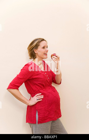 Pregnant woman eating apple Banque D'Images