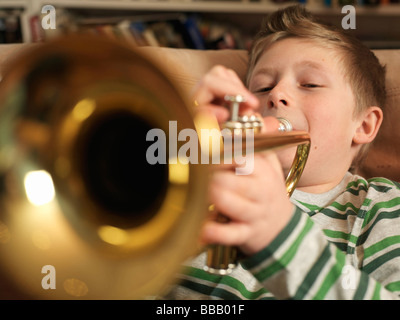 Garçon, 11 playing trumpet Banque D'Images